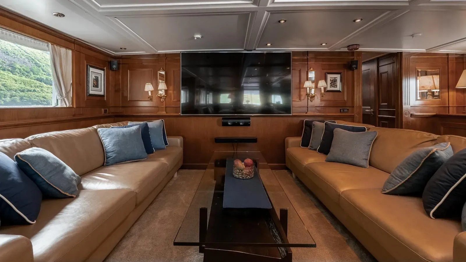 Main salon lounge with leather sofas and television