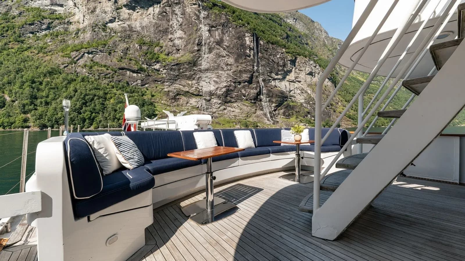 Upper deck lounge beneath the staircase with mountains beyond