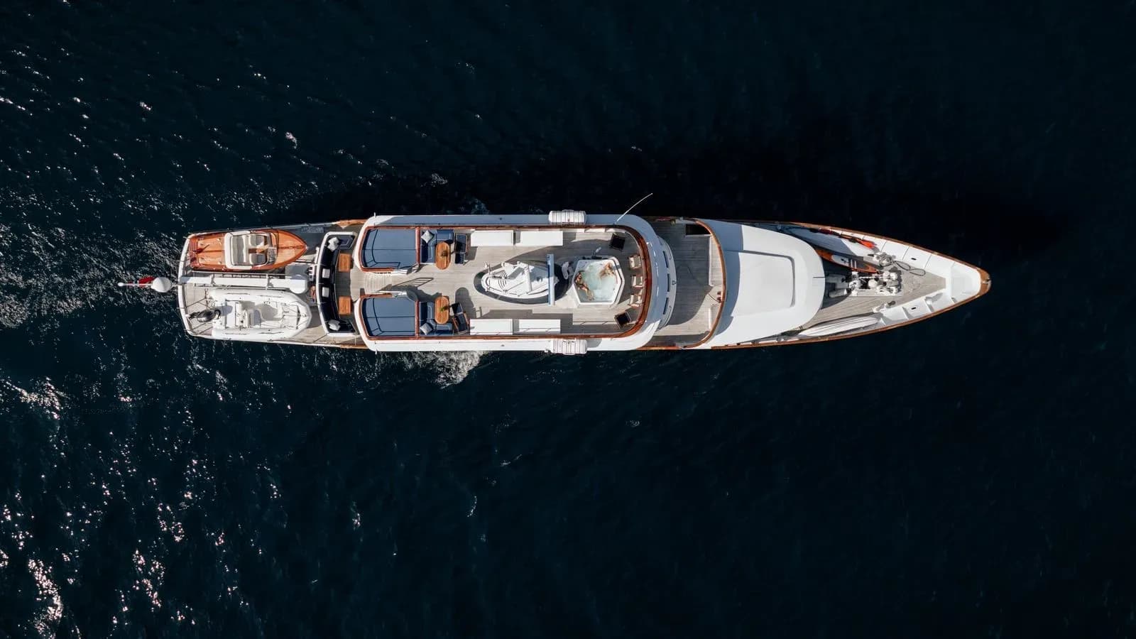 Top-down aerial view of Chantal cruising in dark blue water